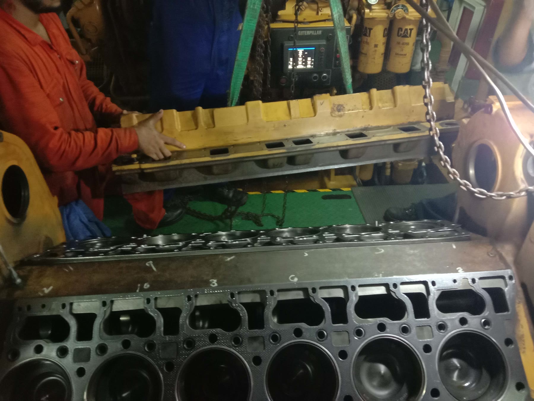 Diesel cylinder head being lifted during an engine overhaul