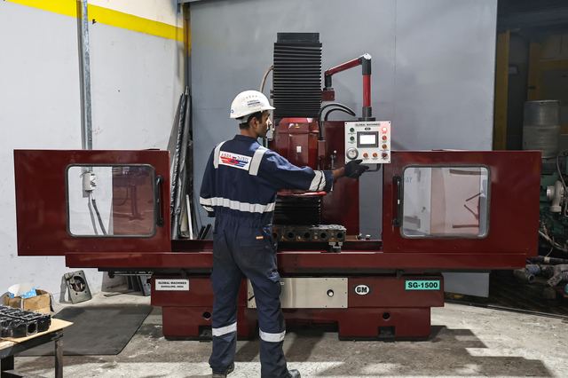 Technician operating machining equipment
