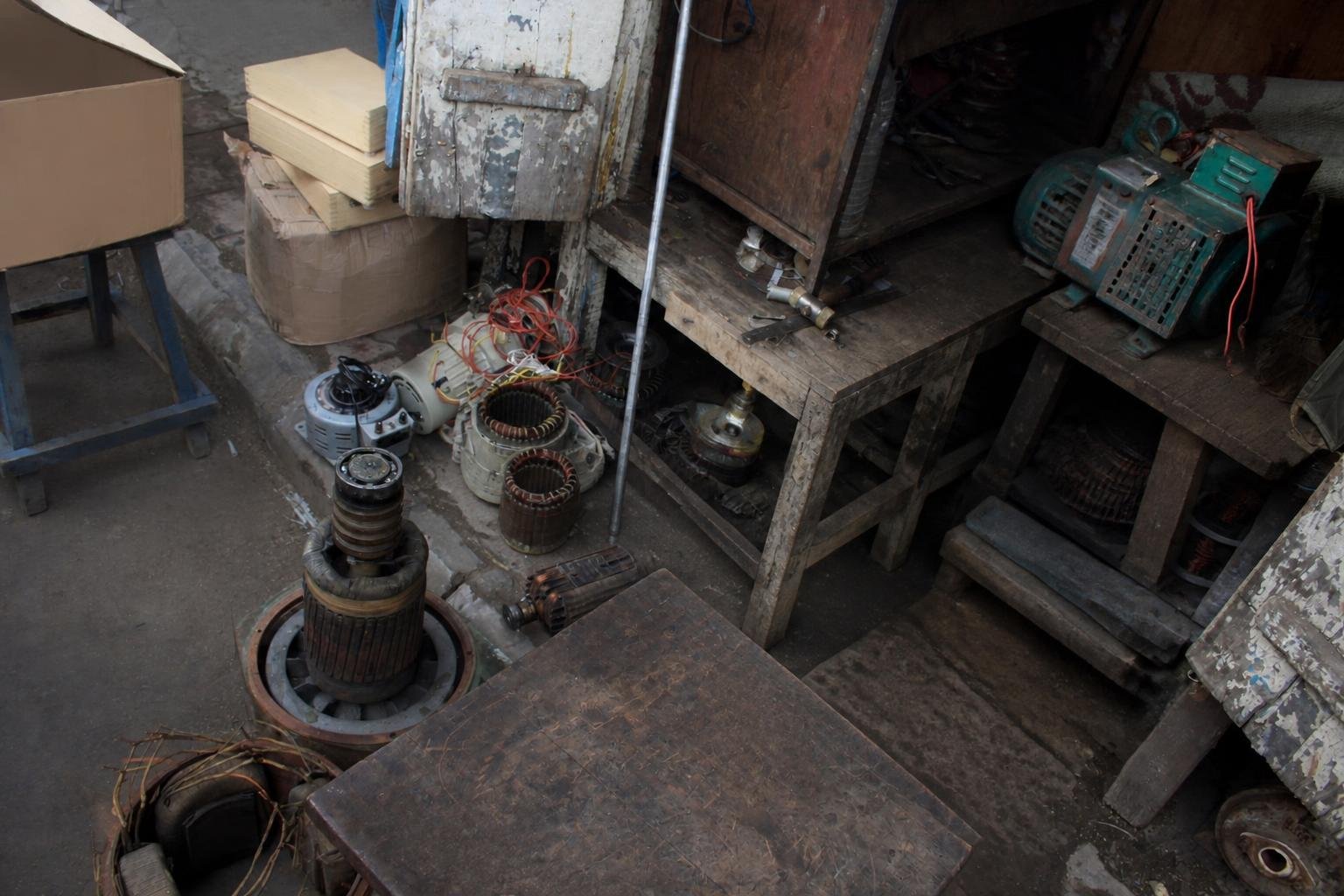Technician repairing generators and electric motors while replacing windings in a busy workshop.
