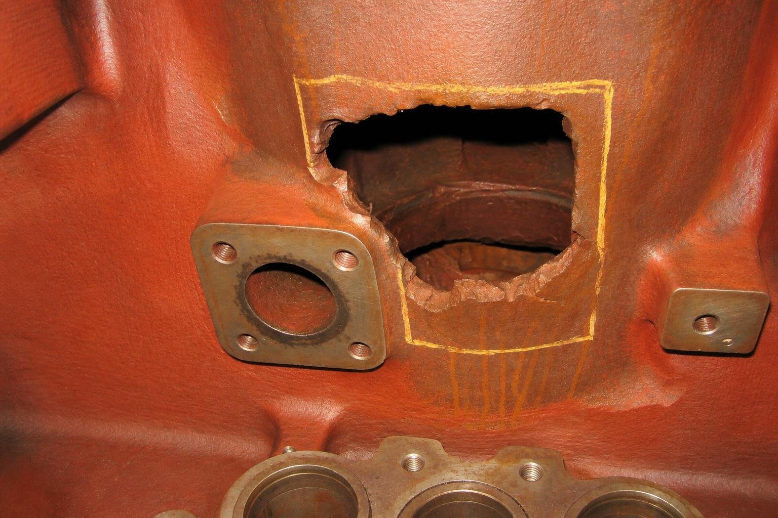 Large broken opening and crack in the cast wall of a diesel engine block before repair