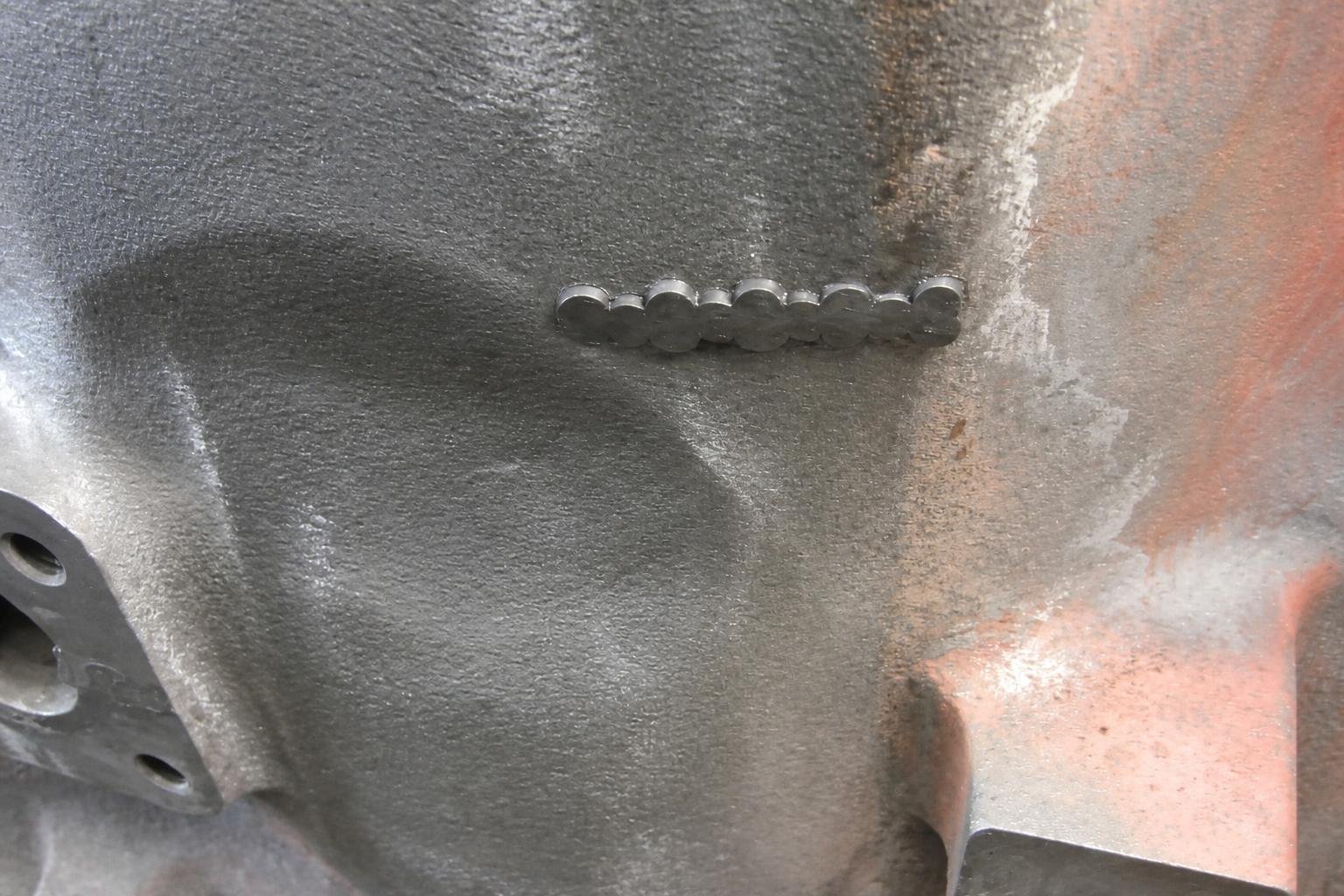 Installed metal-stitching locks across a repaired cast-iron engine-block crack